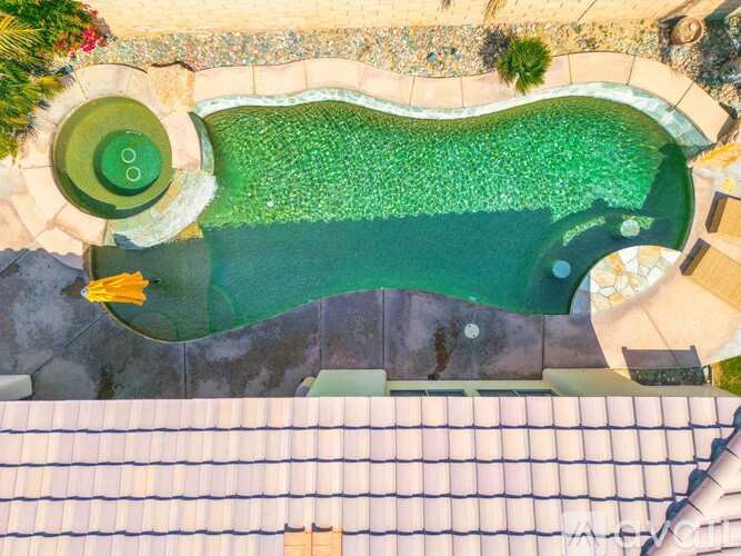 A green and blue pool surrounded by a stone border.