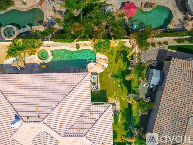 A bird's eye view of a resort with a large swimming pool and a smaller one nearby.