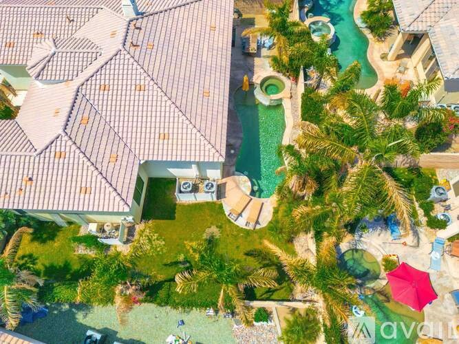 A bird's eye view of a resort with a pool and palm trees.