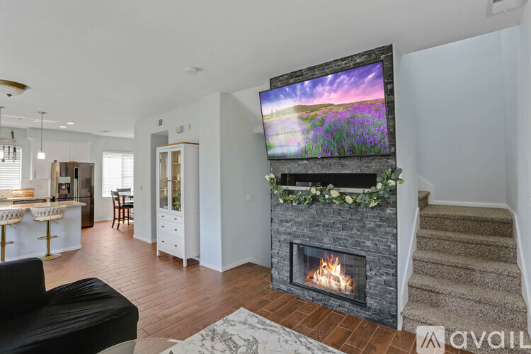 A modern living room with a fireplace and a flat screen TV mounted above it.