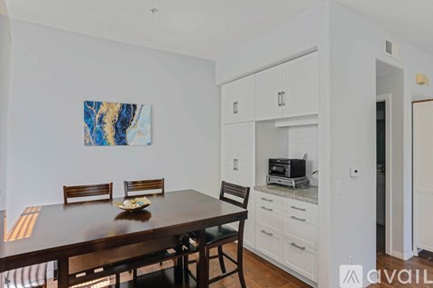 A dining room with a wooden table and chairs.