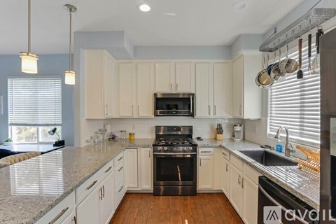 A kitchen with a black stove top oven and white cabinets.
