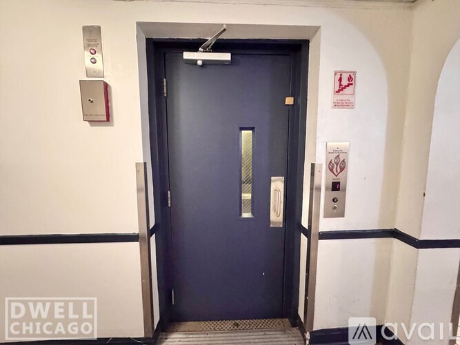 A black door with a silver handle and a silver plate above it.