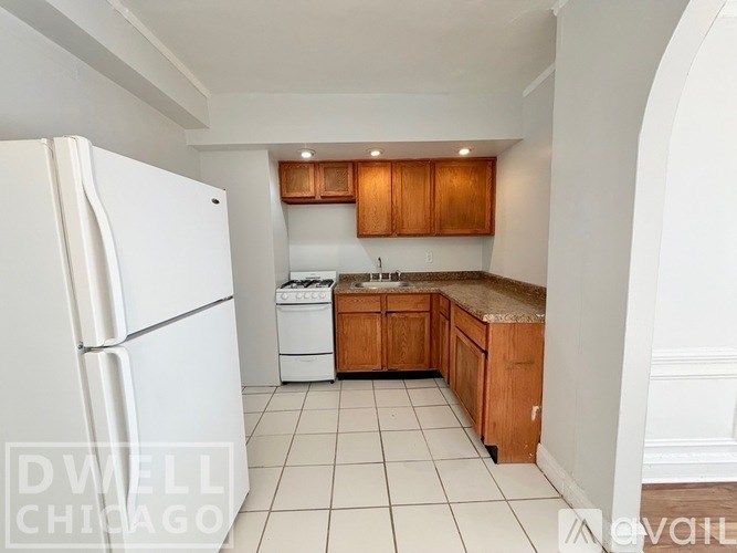 A white room with a refrigerator and arched doorways.