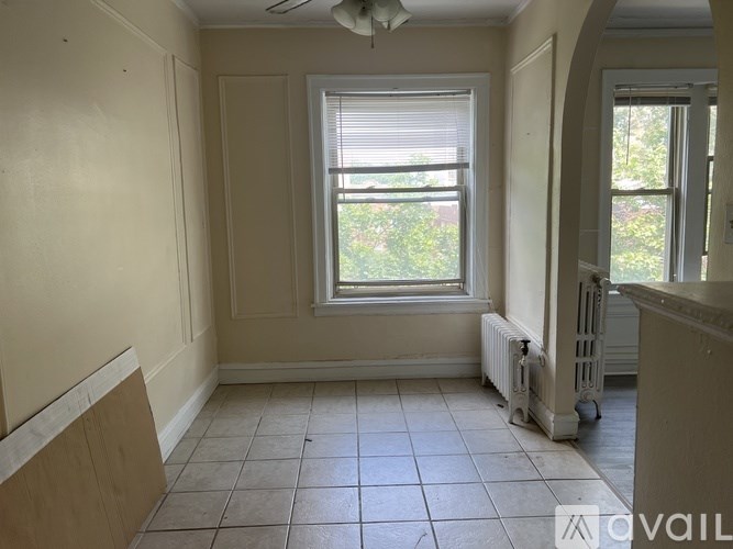 A kitchen with a black refrigerator, stainless steel oven, and wooden cabinets.