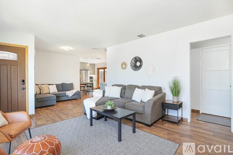 A living room with a grey couch and a wooden chair.