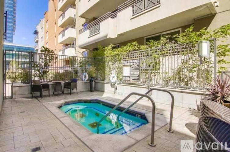 A small pool in a courtyard surrounded by a metal fence.