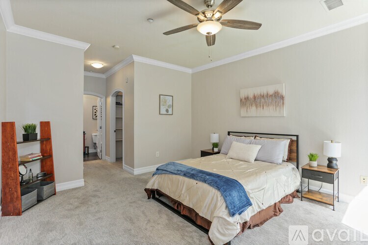 A bedroom with a bed, a ceiling fan, and a nightstand.