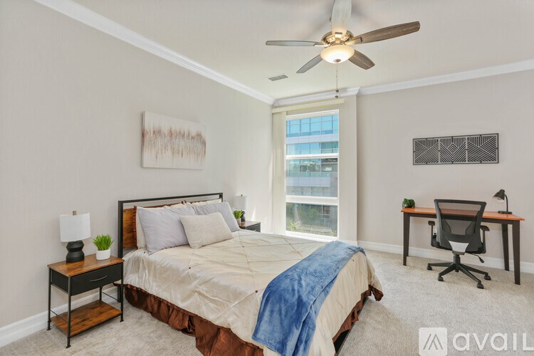 A bedroom with a bed, desk, and chair.