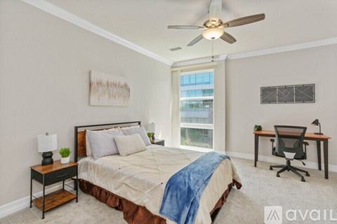 A bedroom with a bed, desk, and chair.