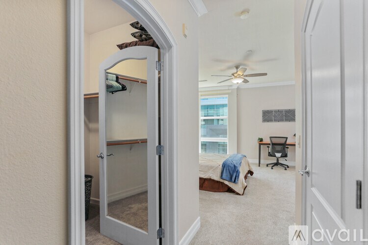 A bedroom with a bed, desk, and chair is visible through an open door.