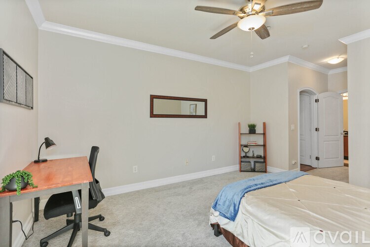 A bedroom with a bed, desk, and chair.