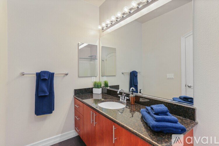 A bathroom with a sink, mirror, and towel rack.