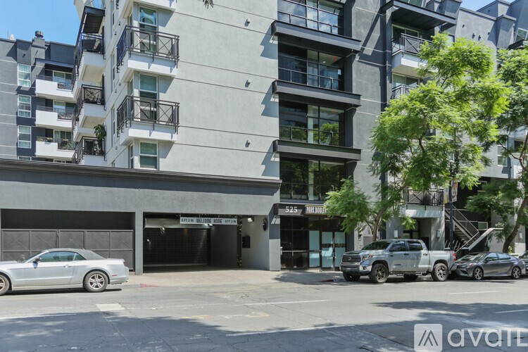 A modern apartment building with a car parked in front.
