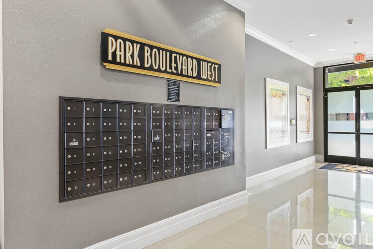 A wall of mailboxes is lined up on a wall under a sign that says Park Boulevard West.