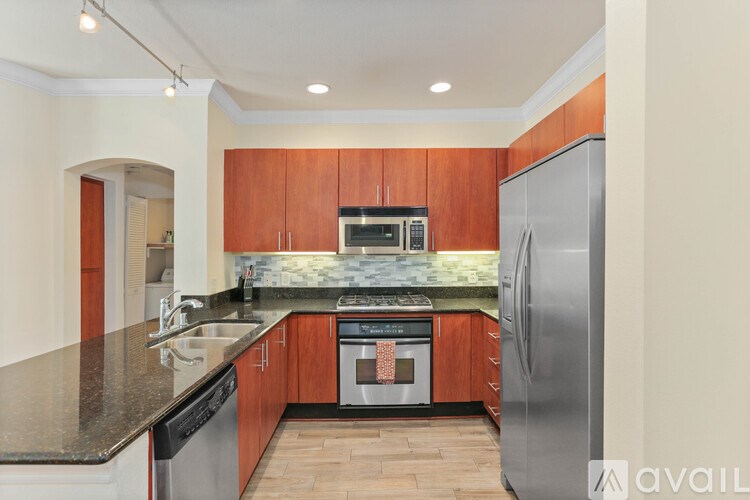 A kitchen with wooden cabinets and a black countertop.