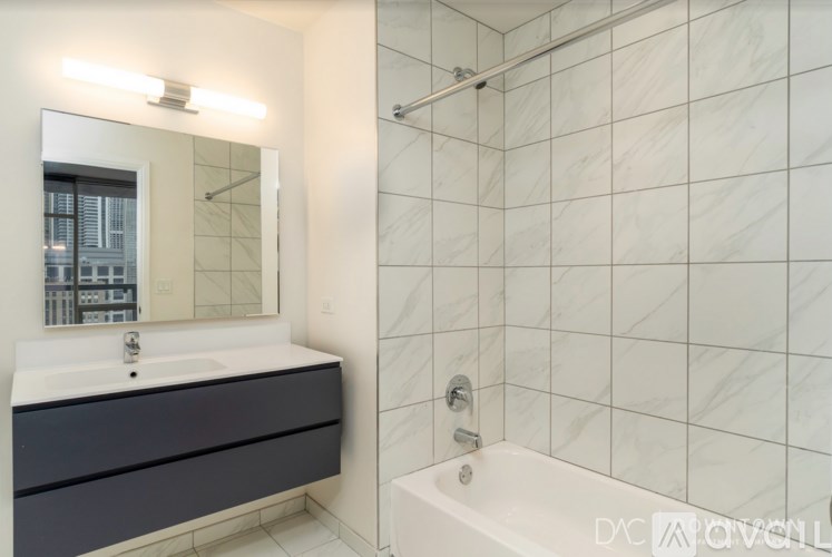 A white bathroom with a white tub and a white sink.