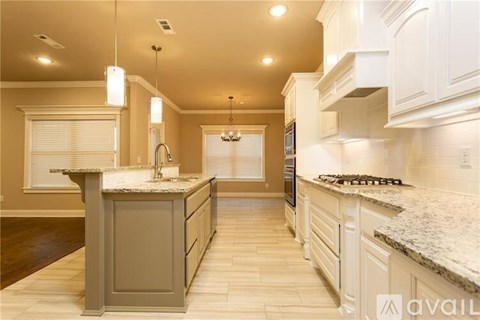 A kitchen with a granite countertop and white cabinets.