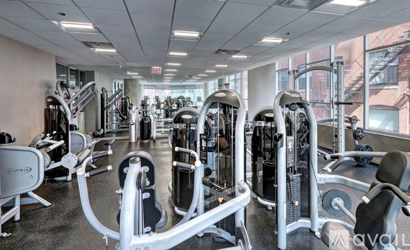 A gym with a variety of equipment including treadmills, weights, and exercise machines.