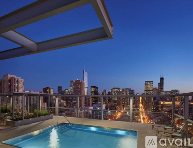 A rooftop pool with a city skyline at dusk.