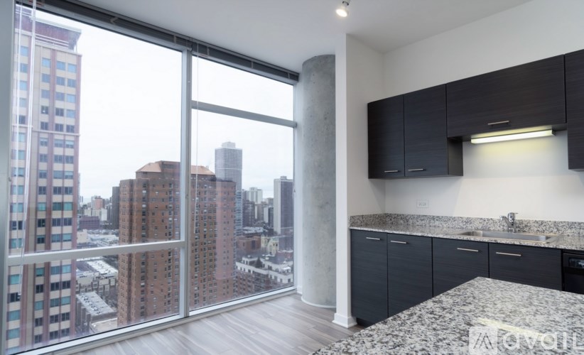 A modern kitchen with a view of the cityscape outside the window.