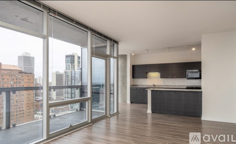 A spacious living area with a kitchen and a view of the city.