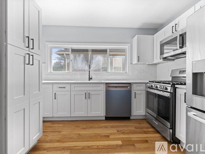 A kitchen with white cabinets and stainless steel appliances.