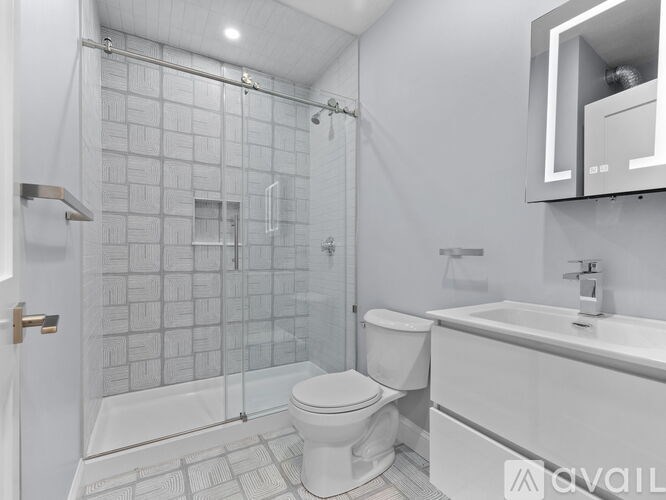 A white bathroom with a toilet, sink, and shower.