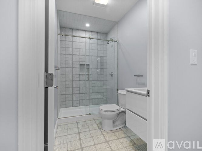 A bathroom with a toilet, a shower with a glass door, and a bathtub.