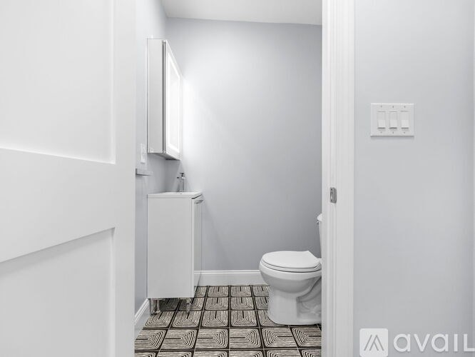 A bathroom with a toilet and a cabinet.