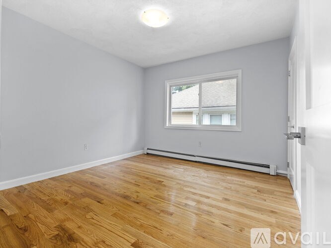 A room with wooden flooring and a window.