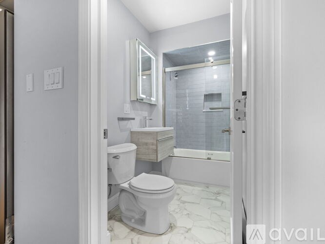 A white bathroom with a toilet, sink, and bathtub.