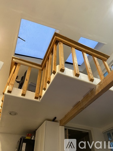 A room with a skylight and wooden beams.