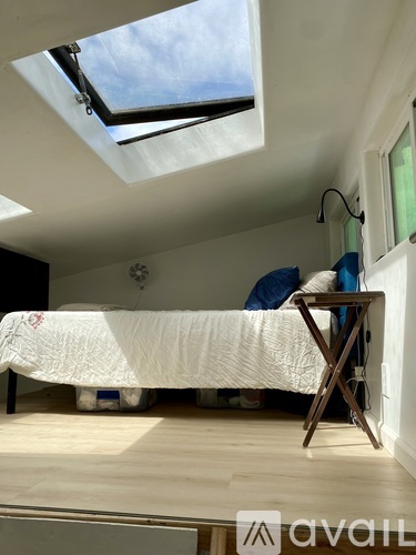 A bedroom with a bed and a skylight.