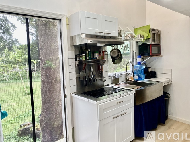A kitchen with white cabinets and a blue tablecloth.