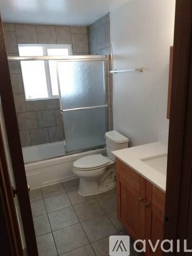 A bathroom with a toilet, sink, and shower.