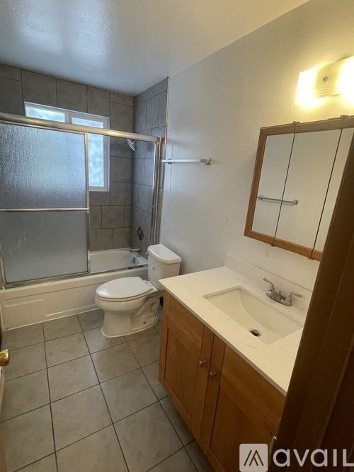 A bathroom with a toilet, sink, and shower.