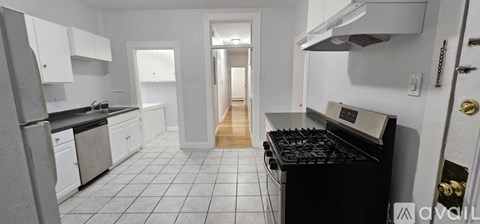 A kitchen with white cabinets and a black stove top oven.