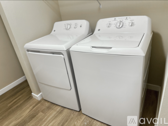 Two white front loading washing machines in a small room.