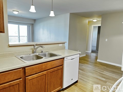 A kitchen with wooden cabinets and a white dishwasher.