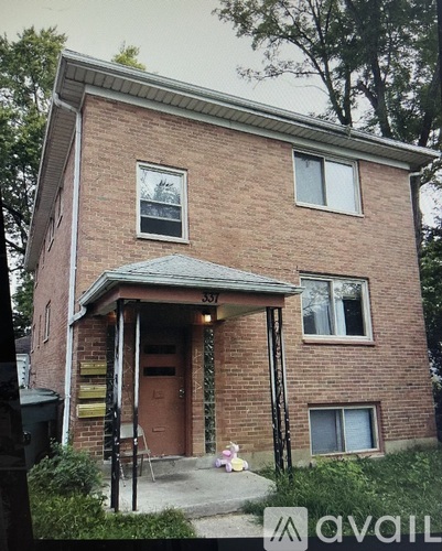 A brick house with a porch and a mailbox on the front door.