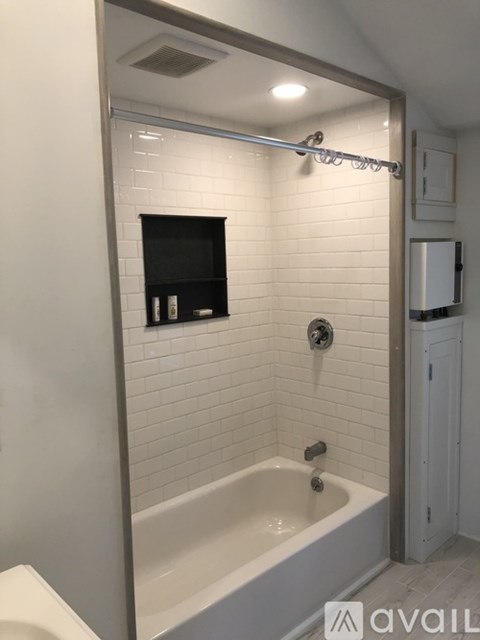 A white bathroom with a white tub and a white sink.