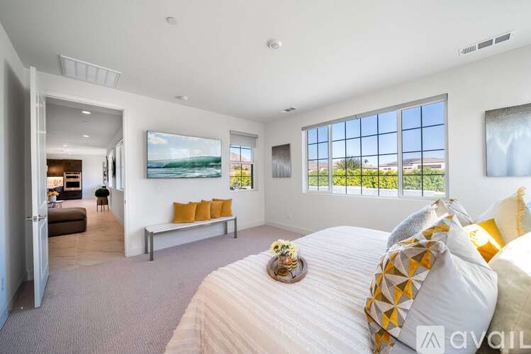 A bedroom with a large bed and a view of the outdoors through the window.