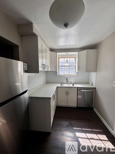 A kitchen with a refrigerator, sink, and cabinets.
