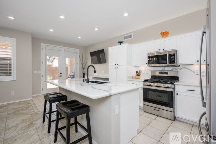 A spacious room with a ceiling fan and tiled flooring.