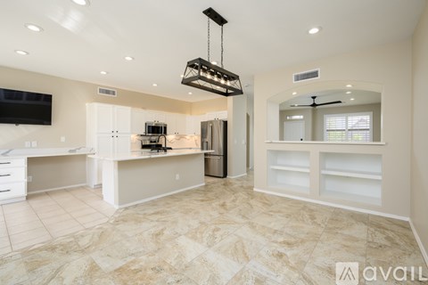 A spacious kitchen with a marble floor and a modern design.