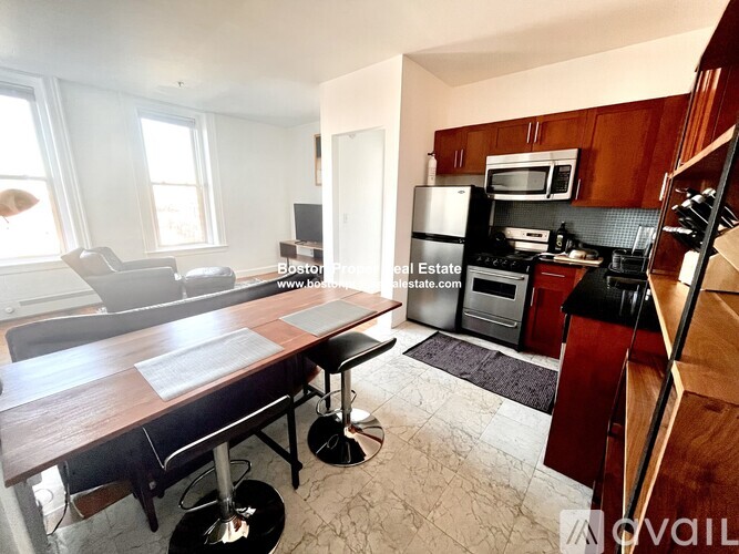 A kitchen with a refrigerator, microwave, and oven.