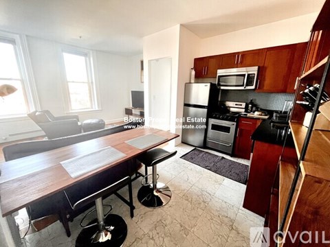 A kitchen with a refrigerator, microwave, and oven.