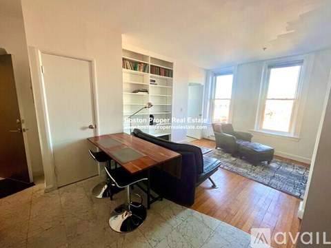 A living room with a wooden table and chairs.