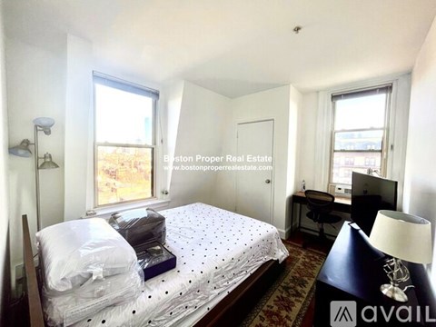A bedroom with a bed, desk, and chair.